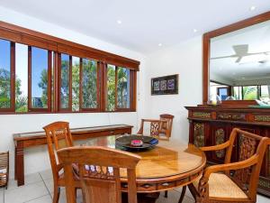 a dining room with a wooden table and chairs at Noosa Dua 2 Balinese Retreat in Noosa Heads