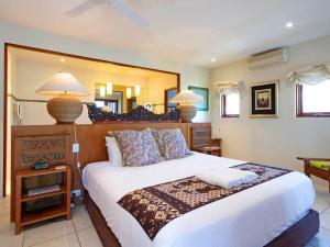 a bedroom with a large bed and a large mirror at Noosa Dua 2 Balinese Retreat in Noosa Heads