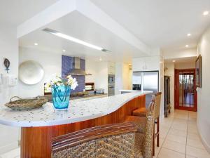 a kitchen with a counter with a vase of flowers on it at Noosa Dua 2 Balinese Retreat in Noosa Heads