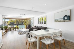 a living room with a white table and chairs at Noosa Haven Apt 6 Riverside Retreat in Noosaville