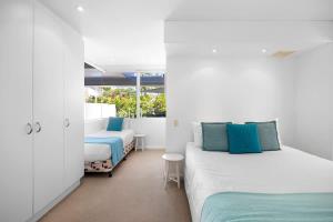 two beds in a room with white walls at Noosa Haven Apt 6 Riverside Retreat in Noosaville +13 photos