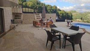 a patio with a table and chairs next to a pool at Moufid villa in Al Mīdān