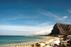 a beach with a bunch of people and the ocean at B&B Cous Cous People in San Vito lo Capo