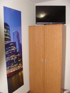 a flat screen tv on top of a wooden cabinet at Guest House Valchanovi in Elkhovo