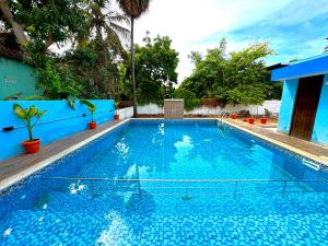 a large swimming pool with blue water in a yard at DPD Beach Hotel in Pondicherry