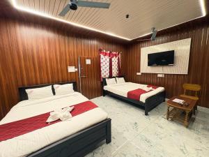 a hotel room with two beds and a tv at DPD Beach Hotel in Pondicherry +45 photos