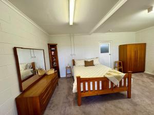 a bedroom with a bed and a mirror in it at Backyard Bliss in Waikerie