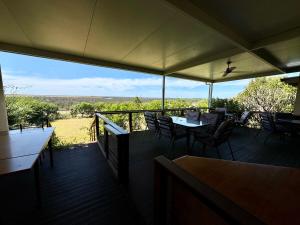 a deck with tables and chairs and a view of a field at Backyard Bliss in Waikerie