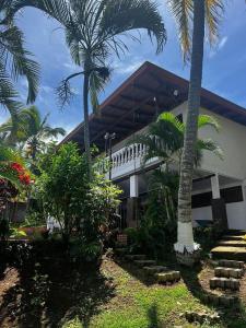 a building with palm trees in front of it at Casa Eliza in Alajuela
