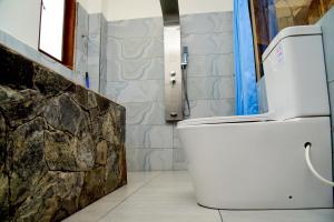 a bathroom with a toilet and a stone wall at Ella Dream Mount in Ella +103 photos