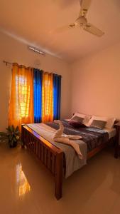 a bedroom with a large bed with a ceiling fan at Homestay INN in Anachal