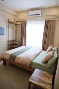 a bedroom with a bed with a window and a shelf at Frania Sea Suites in san juan la union