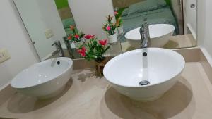 a bathroom with two sinks and a mirror and flowers at Posada Nacha`n - Ka`an in Palenque +73 photos
