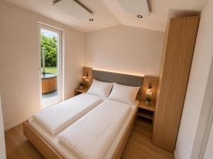 a bedroom with a large bed and a window at Hassberge Chalets in Kirchlauter