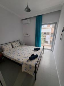 a bedroom with a bed and a large window at Beachfront apartment 10m from the beach in Paralia Dionysiou
