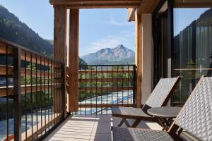 a balcony with two chairs and a view of a mountain at Edelweiss echt-charmant in Sölden