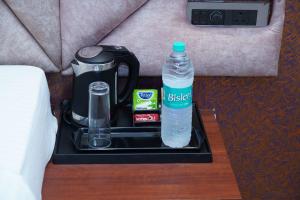 a tray with a bottle of water and a coffee maker at Hotel G Grand Inn in Thanjāvūr +52 photos