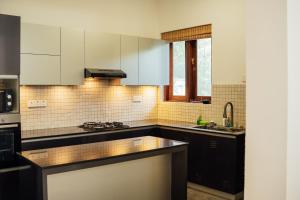 a kitchen with black and white cabinets and a sink at US Apartment in Nochchiyagama +15 photos
