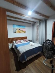 a bedroom with a bed and a fan at Hospedaje Viento in Paracas