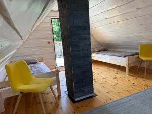 a room with two beds and a yellow chair at Tammeoja puhkemaja in Sõmeru +23 photos