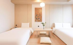 two beds in a room with a table and a painting at ALMOND Hotel in Jinju +19 photos