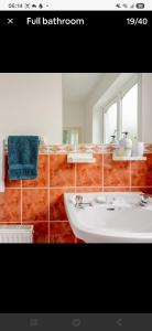 a bathroom with a white sink and a mirror at Lorna's Apartment Self Catering Holiday Home in Milltown Malbay +63 photos