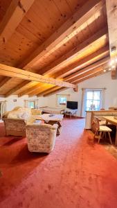 a large room with a bed and tables and chairs at Gästehaus Binderlehen in Schönau am Königssee