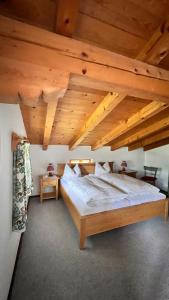 a large bed in a room with wooden ceilings at Gästehaus Binderlehen in Schönau am Königssee