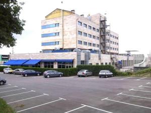 ein Parkplatz mit Autos, die vor einem Gebäude geparkt sind in der Unterkunft Hotel Silvota in Lugo de Llanera