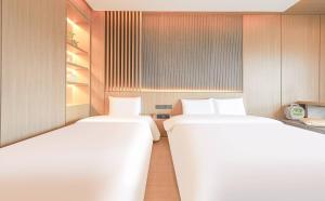 two twin beds in a room withermottermottermott at ALMOND Hotel in Jinju