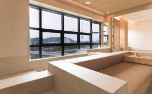 a large bathroom with a large window and a large tub at ALMOND Hotel in Jinju