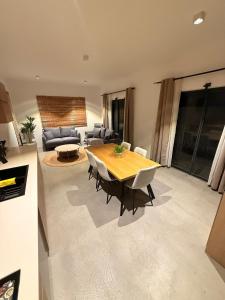 a living room with a wooden table and chairs at La Casa Floréal in Curepipe +3 photos
