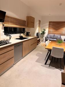 a kitchen and living room with a table and a couch at La Casa Floréal in Curepipe
