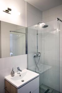a white bathroom with a sink and a shower at Apartament nad Odrą in Wrocław