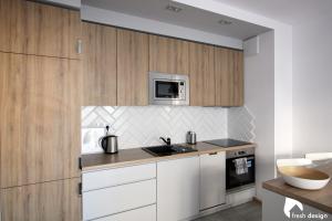 a kitchen with white cabinets and a microwave at Apartament nad Odrą in Wrocław