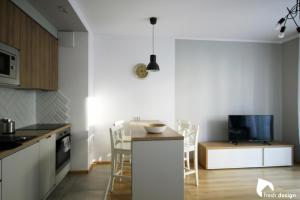 a kitchen with a counter and a table with chairs at Apartament nad Odrą in Wrocław