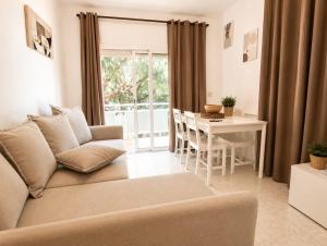 a living room with a couch and a table at Apartamentos Baymar Playa de Aro in Platja d'Aro