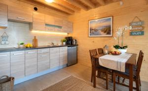 a kitchen with a table and a dining room at Bursztynowe Domki in Sarbinowo +6 photos