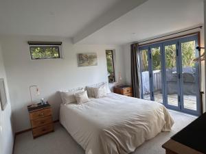 a bedroom with a white bed and a large window at Palm Heights in Palm Beach