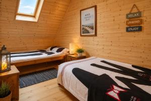 a bedroom with two beds in a log cabin at Bursztynowe Domki in Sarbinowo