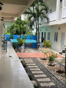 a courtyard of a house with palm trees at La Mer Mũi Né Hotel in Ấp Thiện Long