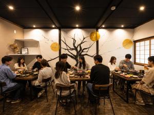 a group of people sitting at tables in a room at Yuimaru EAST - 最大18名貸切OK in Kanazawa
