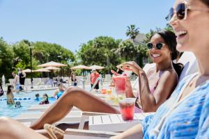 three women sitting at a table by a pool at Wild Dunes Resort - Sweetgrass Inn and Boardwalk Inn in Isle of Palms