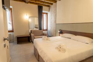 a bedroom with a bed with towels on it at Montenero City Rooms in Verona
