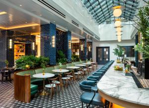a bar with tables and chairs in a restaurant at Dream Nashville, by Hyatt in Nashville