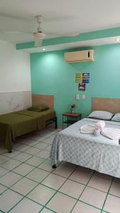 a bedroom with two beds and a blue wall at Posada Nacha`n - Ka`an in Palenque