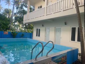 a swimming pool in front of a house at La Mer Mũi Né Hotel in Ấp Thiện Long