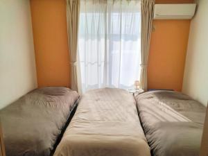 two beds in a room with a window at Winston in Chiba