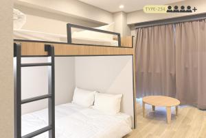 a bedroom with bunk beds with a desk and a table at Luma Urban Hotel 高田馬場 in Tokyo