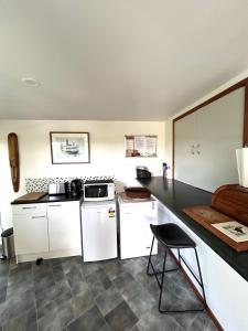 a kitchen with white appliances and a black counter top at Palm Heights in Palm Beach